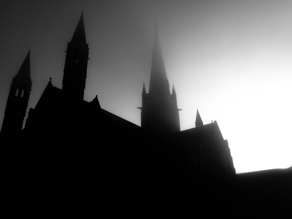 A silhouette of a castle like building with a gray and white sky.