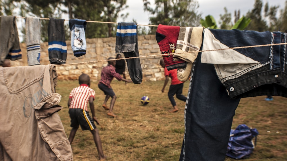 two boys playing under clothesline