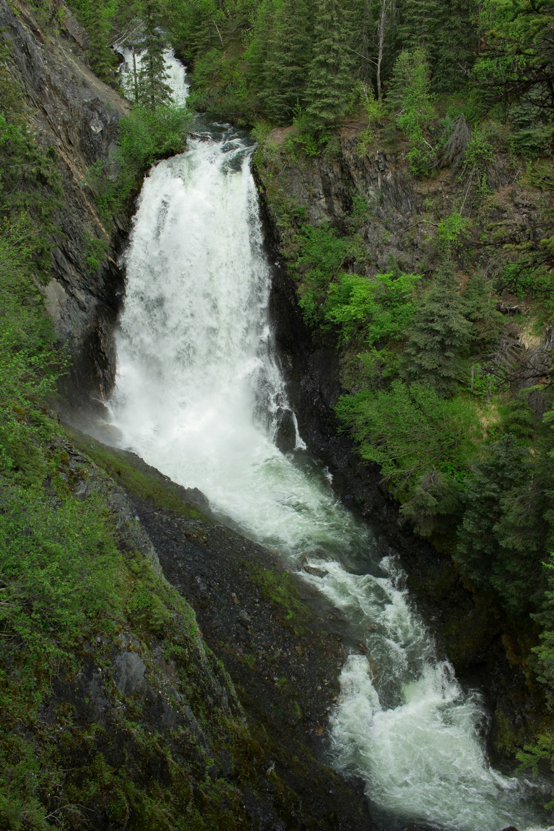 waterfalls in the middle of green grass covered mountain