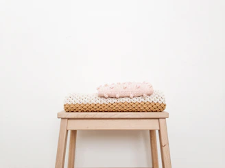 Cozy handmade blankets folded neatly on a vintage chair in warm natural light