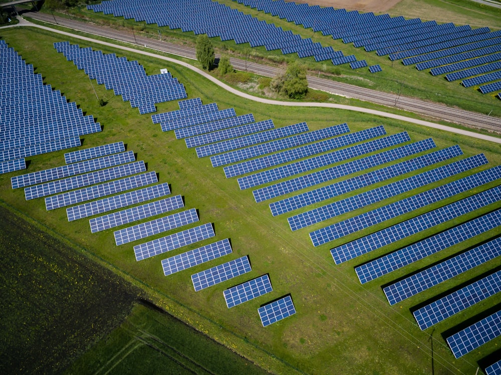 Photographie aérienne d’un champ d’herbe avec des panneaux solaires bleus