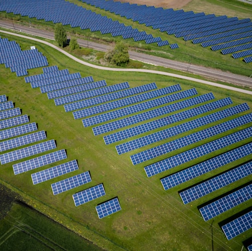 aerial photography of grass field with blue solar panels