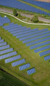 aerial photography of grass field with blue solar panels