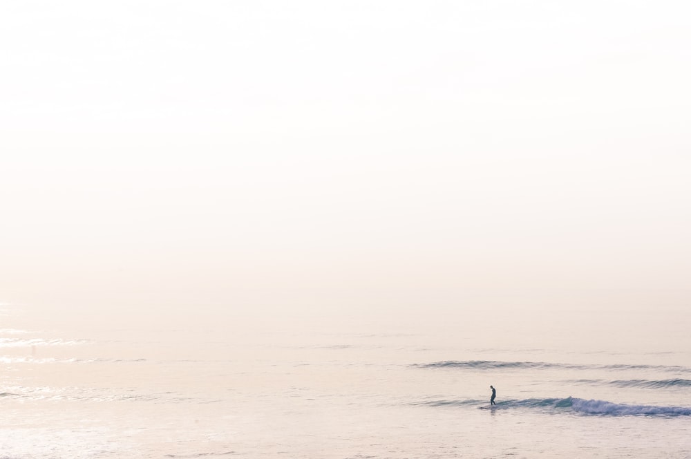 昼間に海でサーフィンをする男性のシルエット
