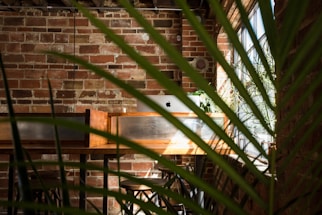 A welcoming rustic farm office with a wooden desk and a laptop, surrounded by greenery and farm animals in the background.
