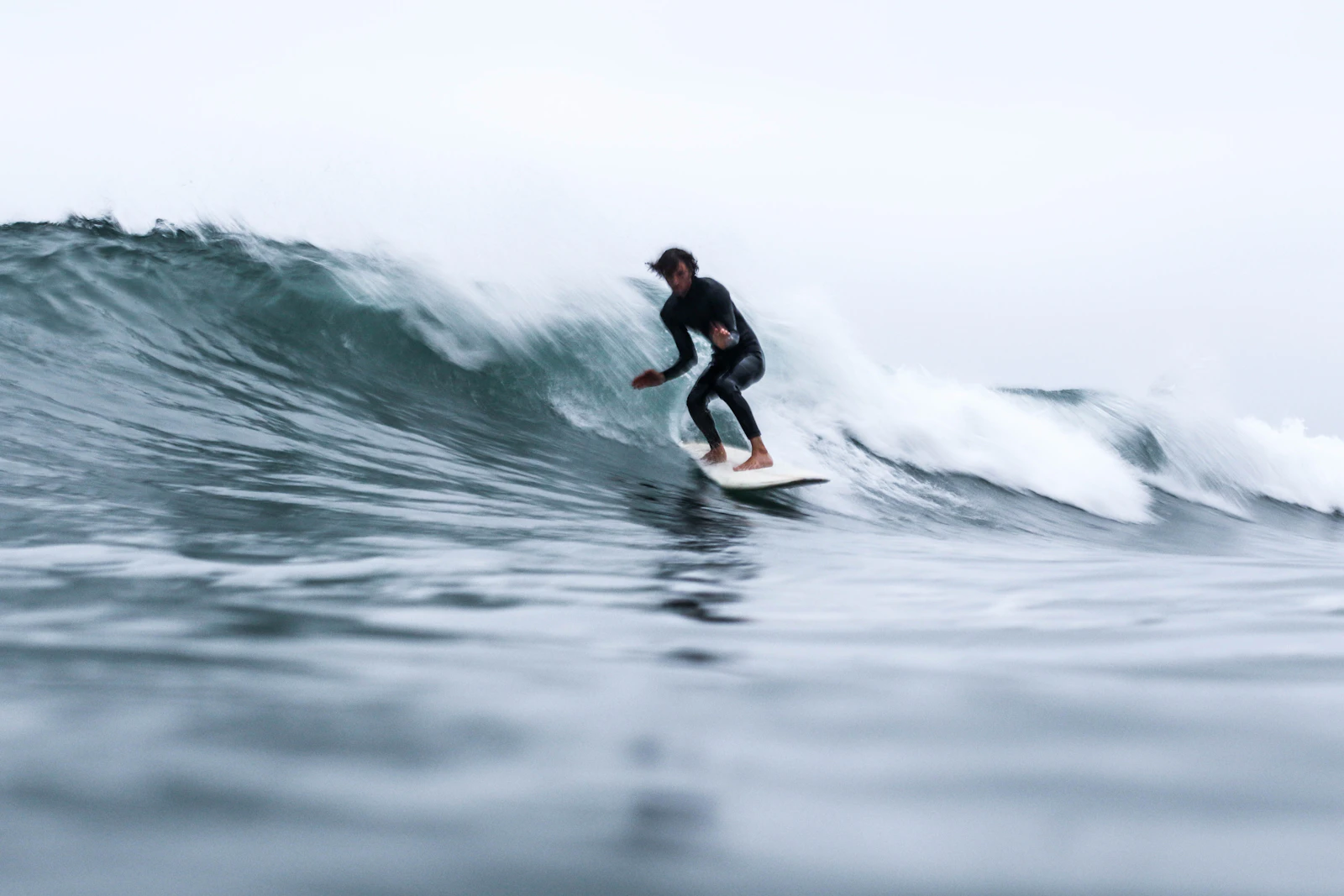 Surfer riding a wave in cold winter water