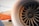 Close-up view of an airplane turbine engine, showcasing the intricate metal blades within the engine casing. The fuselage of the aircraft, painted in an orange and white color scheme, is visible in the background, along with part of the landing gear.