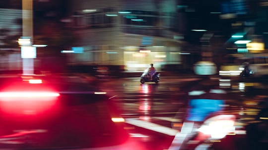 A futuristic motorbike speeding through a neon-lit cityscape at night.