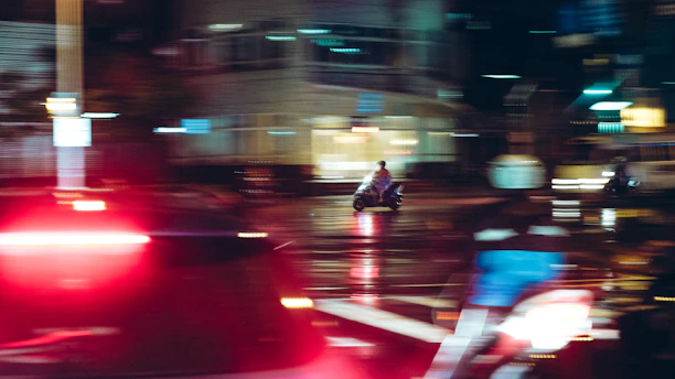 A sleek motorbike courier speeding through city streets at dusk with blurred lights.