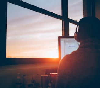 man sitting facing monitor