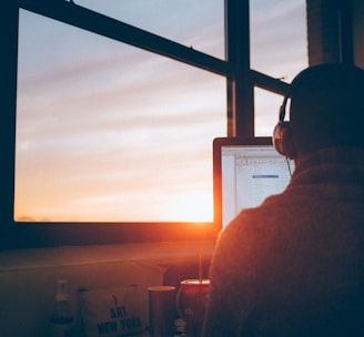 man sitting facing monitor