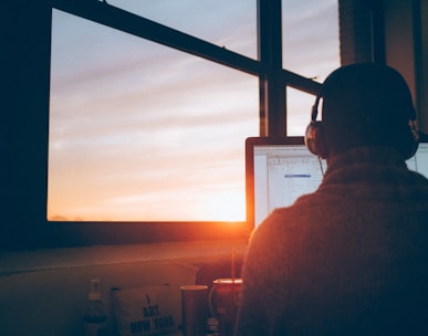 man sitting facing monitor