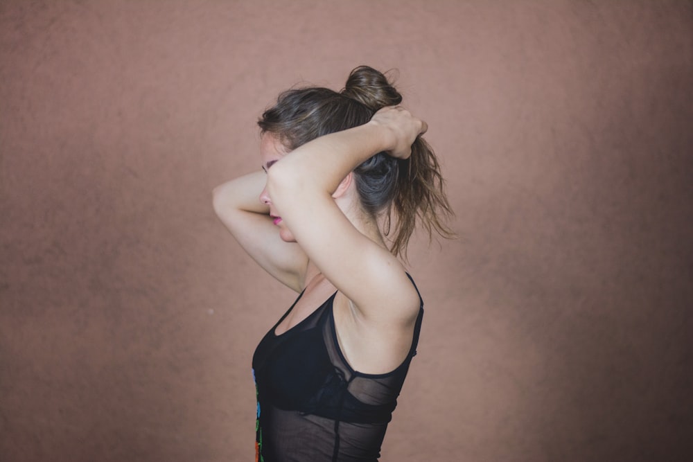 woman standing in front of concrete wall facing sideways