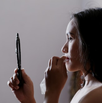 woman looking to mirror and wiping her lips