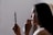 woman looking to mirror and wiping her lips