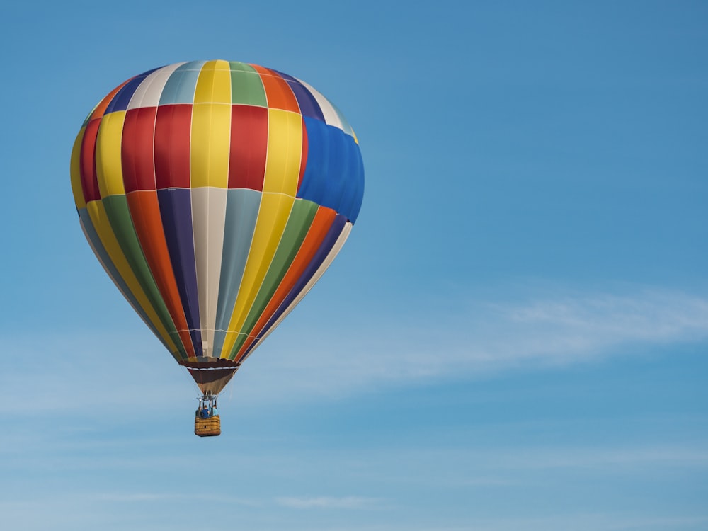 Photographie panoramique de vol de montgolfière bleue, jaune et rouge