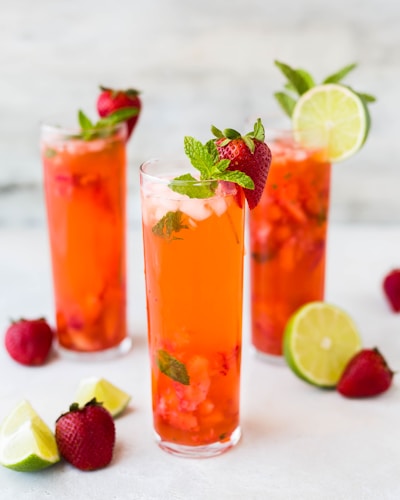 three clear drinking glasses filled with juice