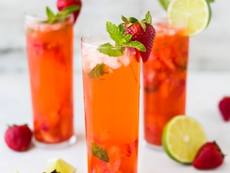 three clear drinking glasses filled with juice