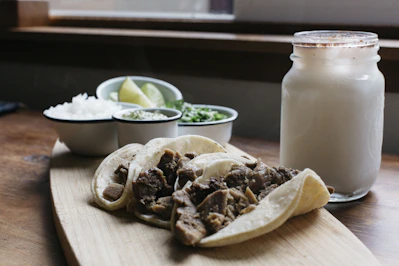 Close-up of colorful street tacos with fresh toppings on a rustic wooden table