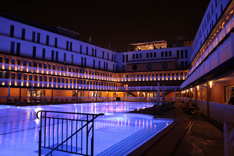 A sleek, modern pool at dusk with soft underwater lighting reflecting on clean architectural lines.