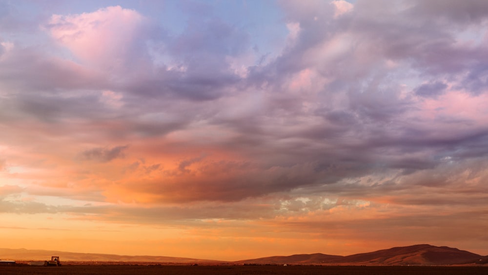 silhouette of mountain under cloudy sky during sunset