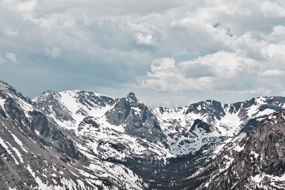 montagnes enneigées sous un ciel nuageux