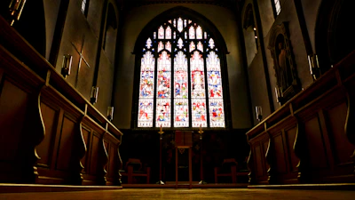 A peaceful church interior with stained glass windows casting colorful light.
