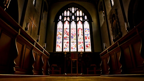 A peaceful church interior with stained glass windows casting colorful light.