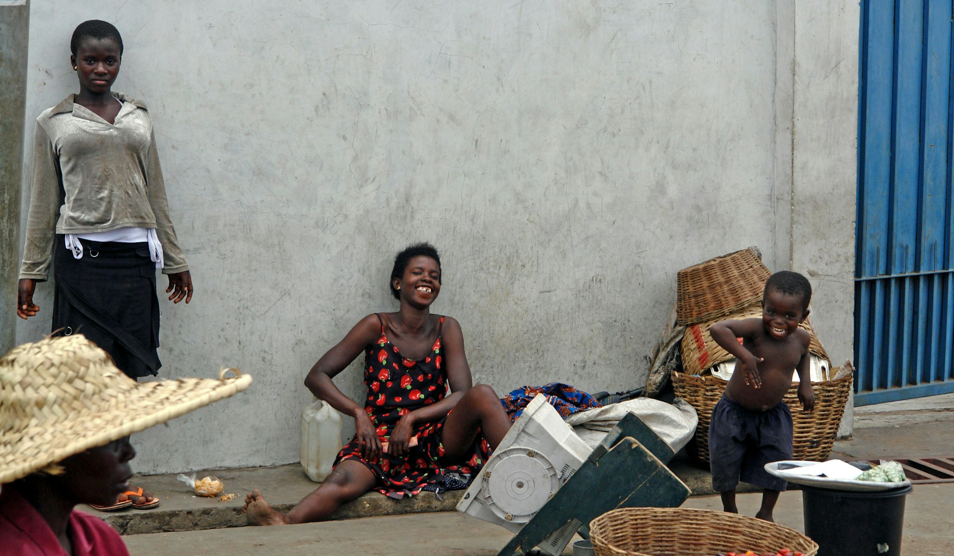 Authentic meeting with locals chatting near a white wall at the entrance of a local school