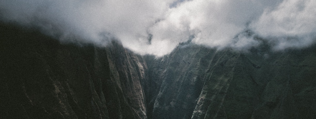 mountains under cloudy blue sky during daytime