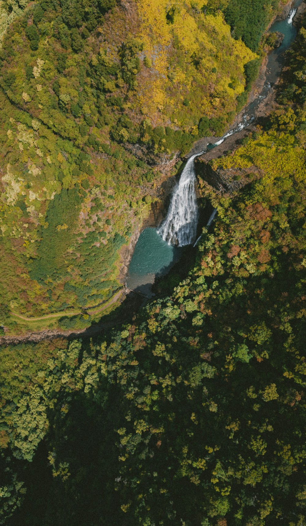 Blick aus der Vogelperspektive auf fließende Wasserfälle zwischen Bergen