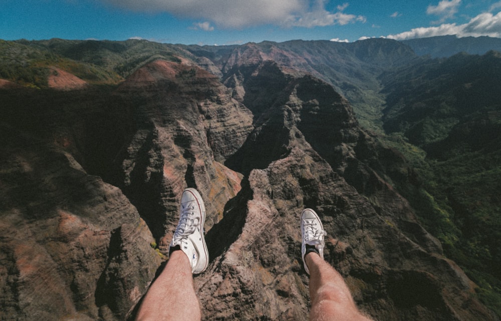 person sitting on mountain during daytime