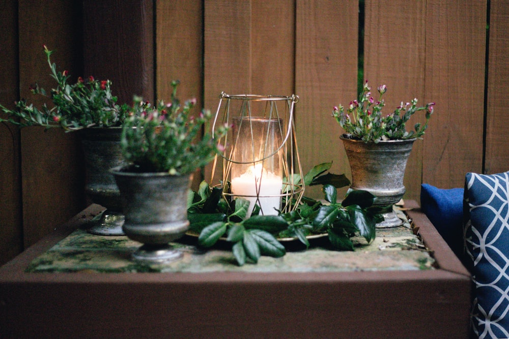 lighted candle on table beside pots