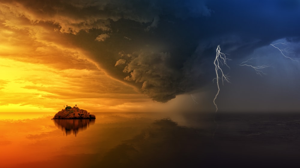 Lightning coming from the sky hitting the ocean during sunset.