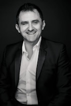 Just esmond smiling warmly while holding a microphone in a modern studio.