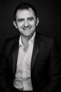 Close-up of a presenter smiling warmly while preparing for a live broadcast.