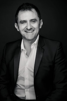 Just esmond smiling warmly while holding a microphone in a modern studio.