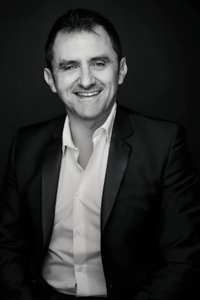 A male executive in a suit smiling naturally during a business portrait session in Klaipėda.