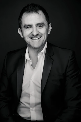 David Conroy smiling warmly backstage, dressed in formal concert attire.