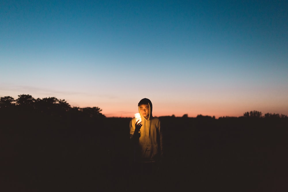 person holding light in dark open space