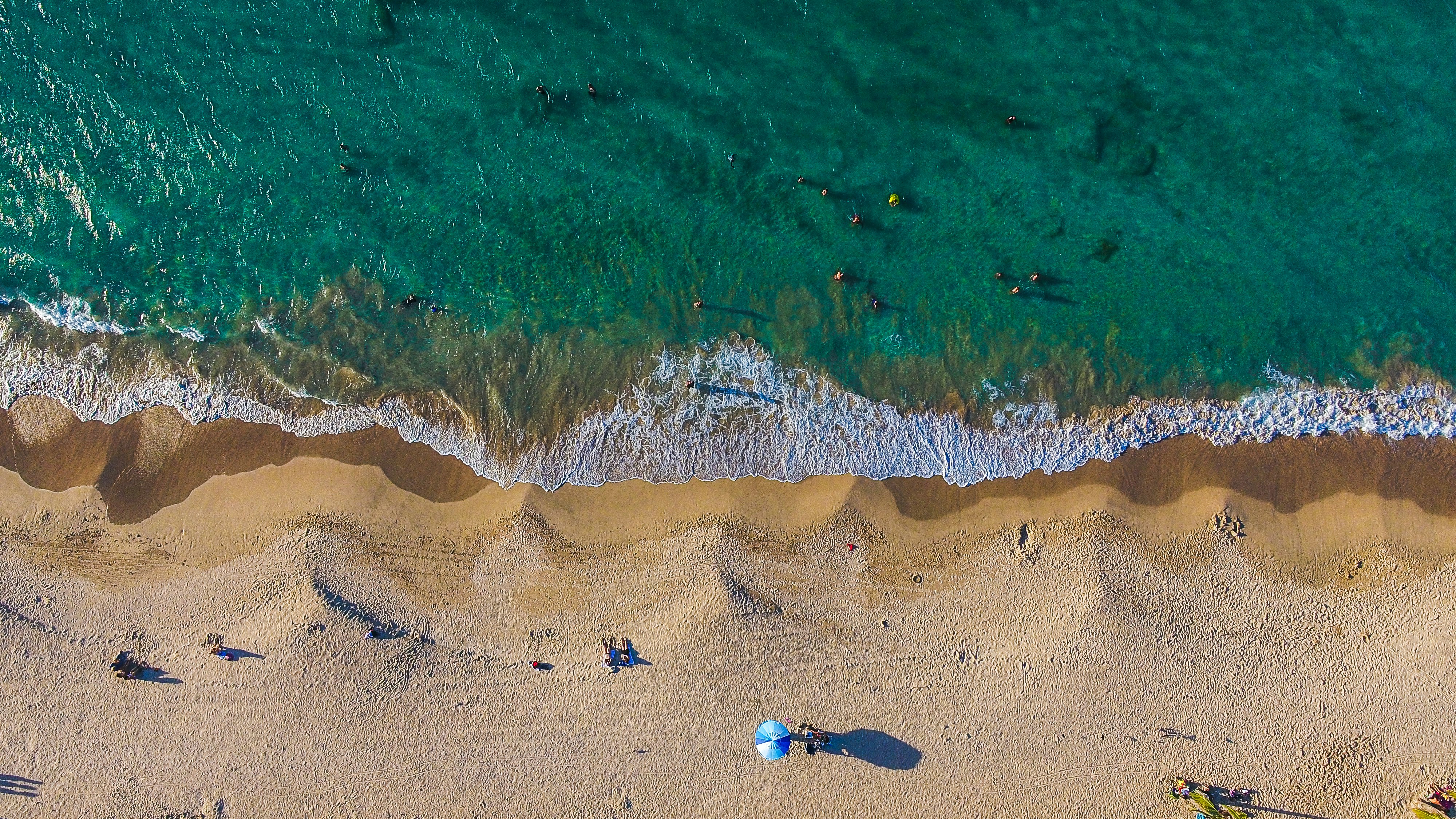 aerial photography of person walking near seashore during daytime