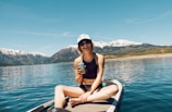 woman wearing black halter neck crop top sitting on boat