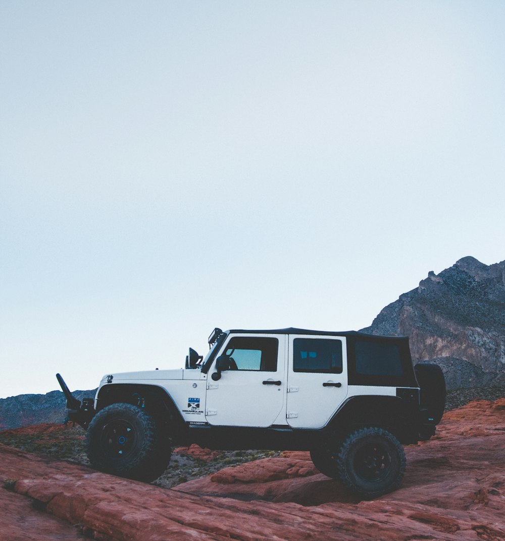 white and black SUV on brown rocks