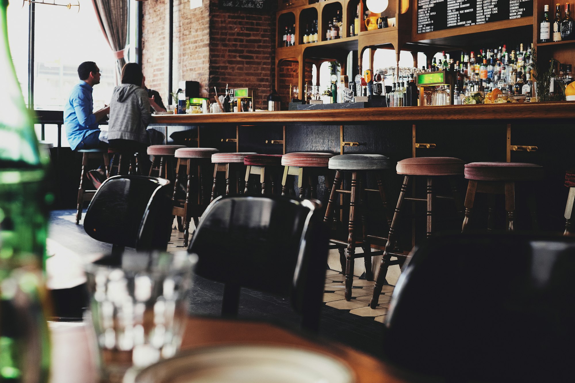 Restaurant bar seating with open chairs for guests looking to drink off the menu.