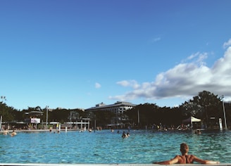 A large outdoor swimming pool surrounded by green grass and trees.