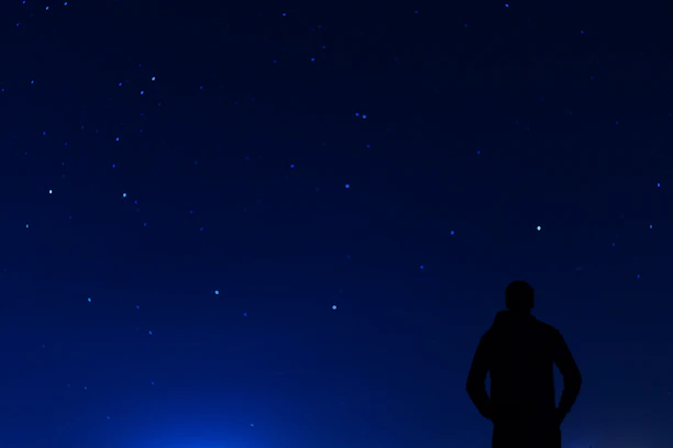 A serene scene of a person gazing at stars under a clear night sky, symbolizing destiny and guidance.