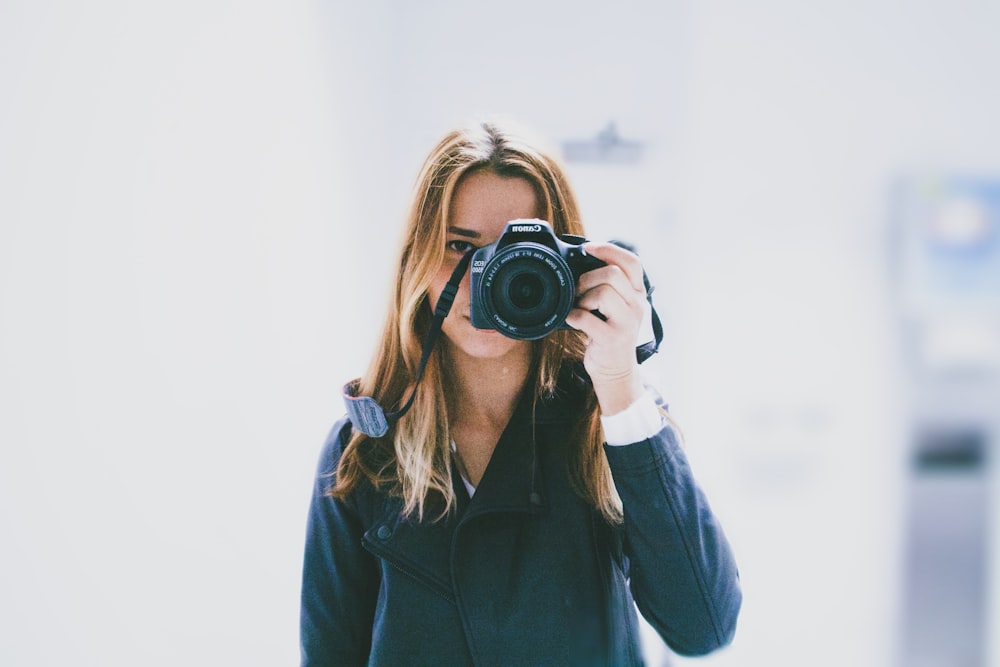 mujer tomando foto con una cámara DSLR