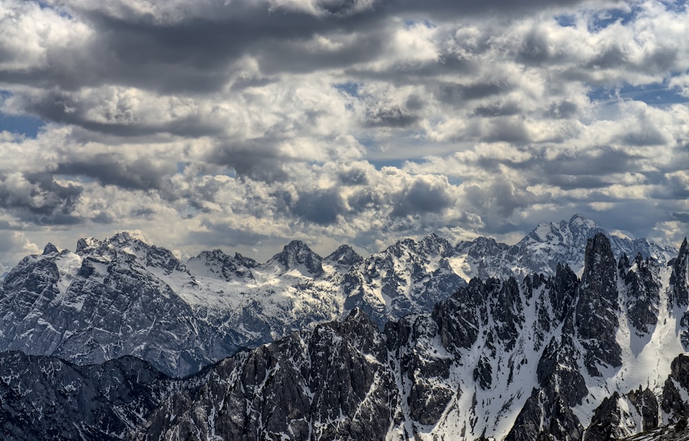 snow-covered mountains under cloudy sky