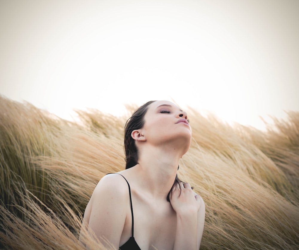 woman sitting along brown plants