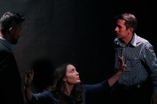 A frustrated team leader mediating a tense discussion between employees during a shift change.